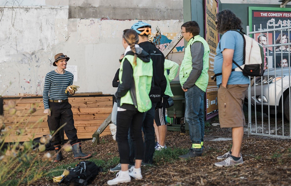 Gardener Levi describes the composting process to bikers at the Organic Market Garden. Photo: Claire Mossong